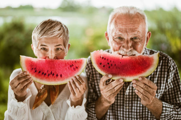 Happy mature couple eating watermelon